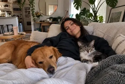 Person relaxing with her dog and cat